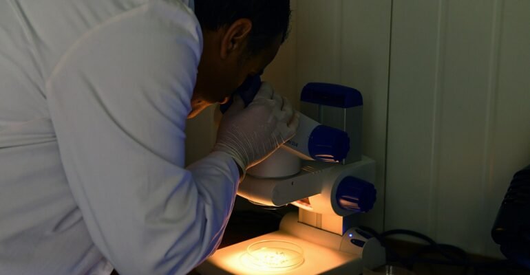 A worker carrying out a quality control inspection, illustrating a medical device quality management system.