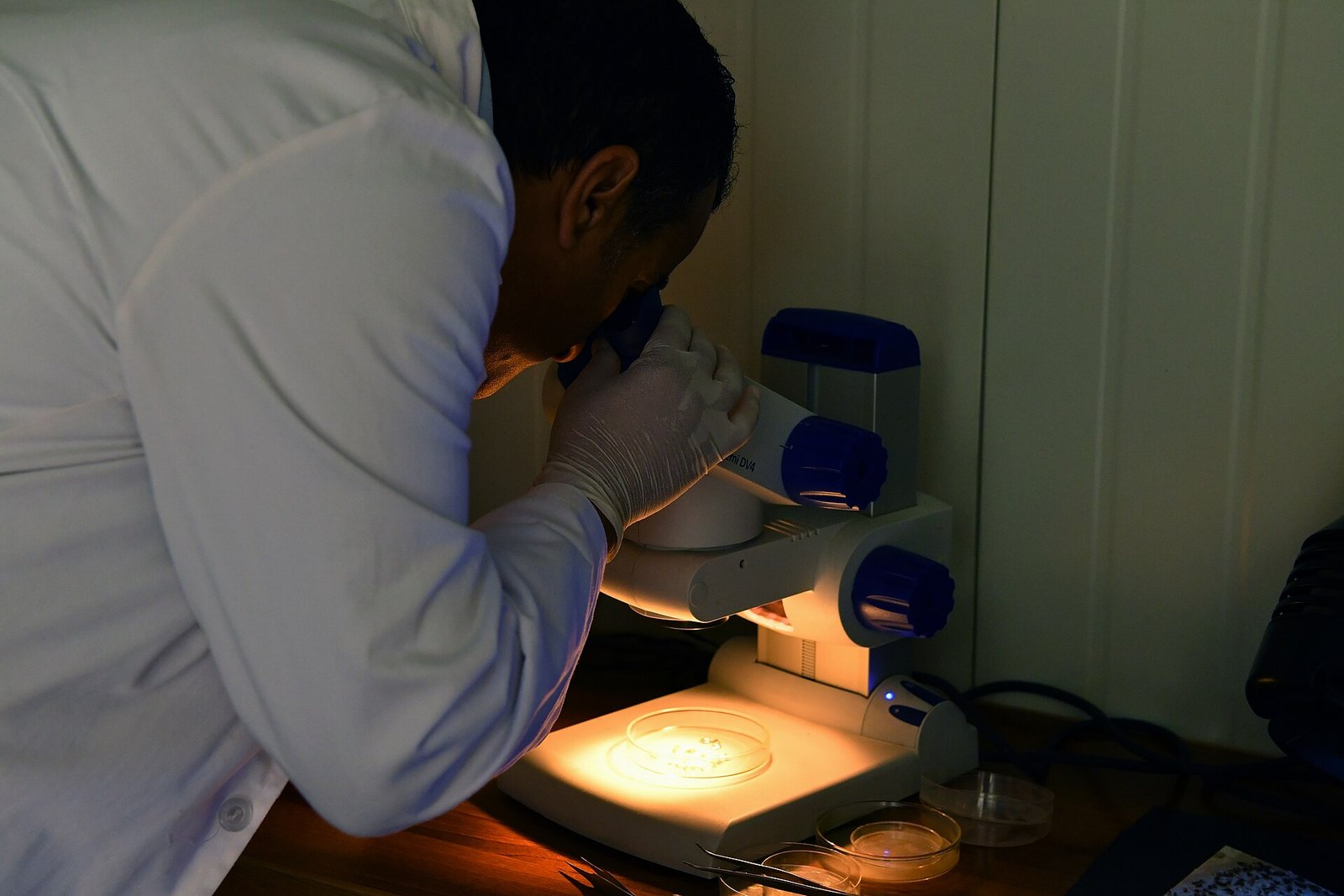 A worker carrying out a quality control inspection, illustrating a medical device quality management system.
