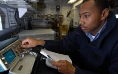 A technician calibrating an oscilloscope in a testing and calibration laboratory, illustrating medical device safety and performance testing.