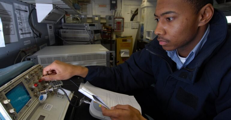 A technician calibrating an oscilloscope in a testing and calibration laboratory, illustrating medical device safety and performance testing.