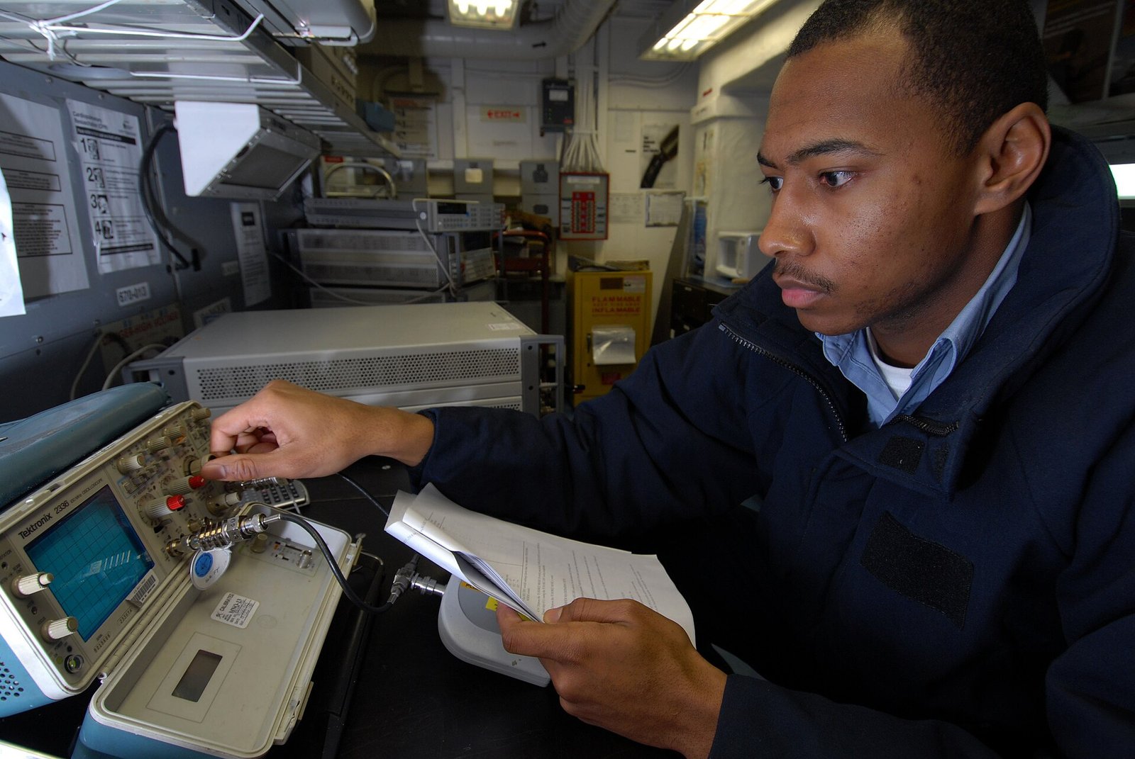 A technician calibrating an oscilloscope in a testing and calibration laboratory, illustrating medical device safety and performance testing.
