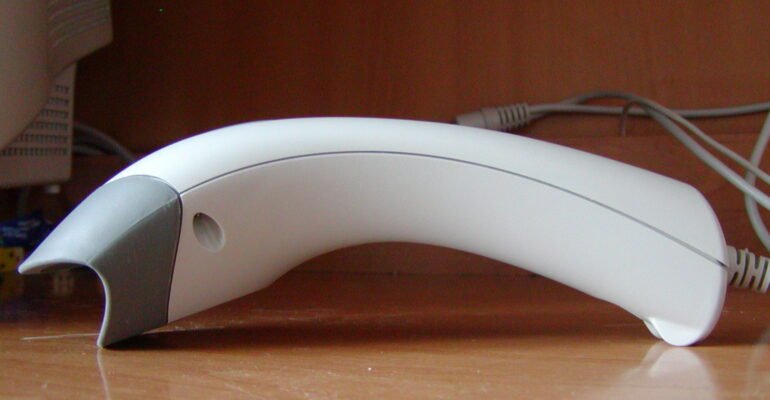 A handheld barcode scanner reading a product code, illustrating Unique Device Identification (UDI) on medical device labels.