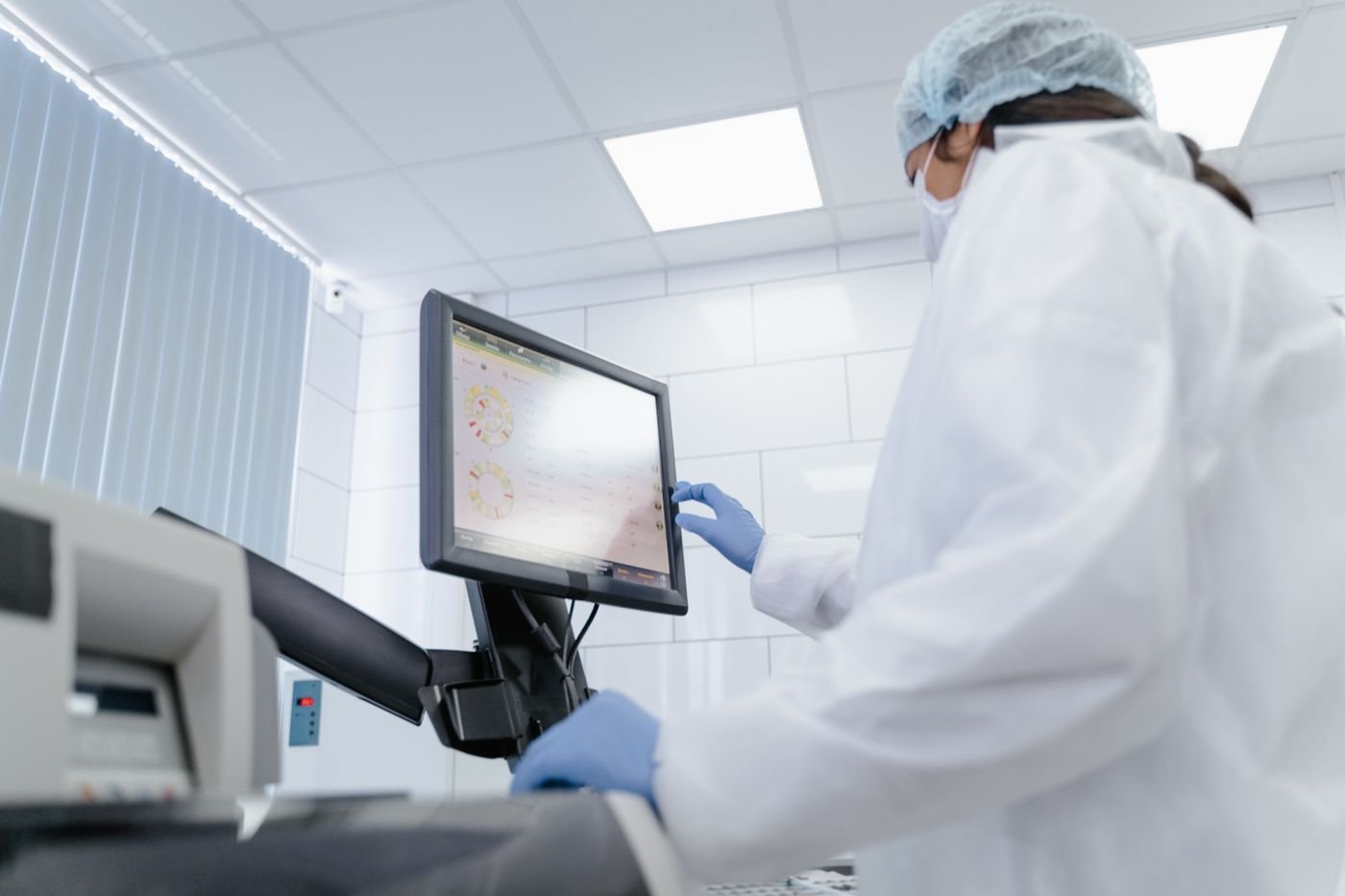 Professional using a touchscreen monitor in a modern laboratory
