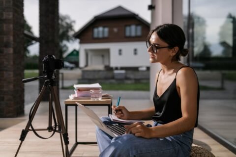 Professional taking notes during an online course on a laptop