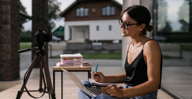 Professional taking notes during an online course on a laptop
