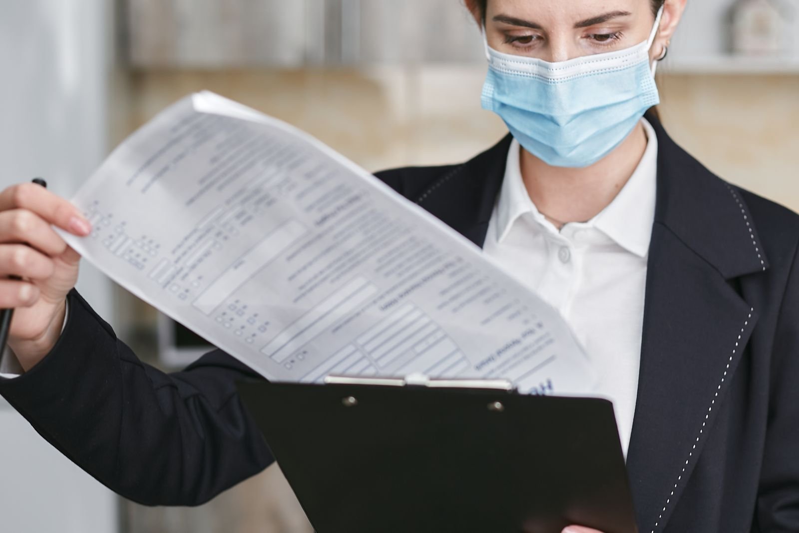 Professional reviewing a document on a clipboard