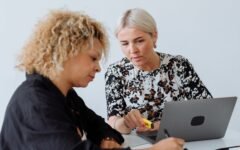 Two colleagues reviewing work together on a laptop